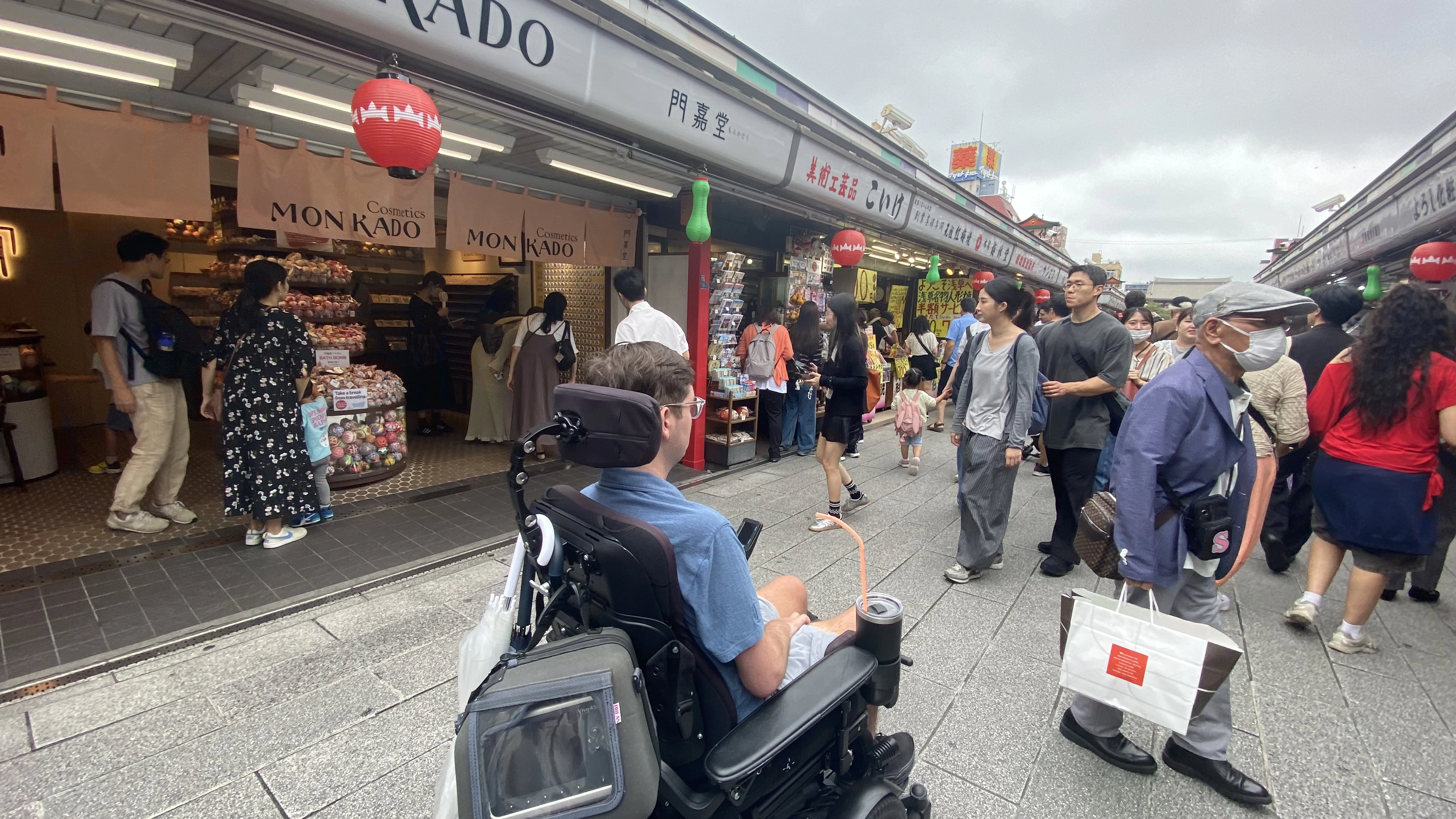 浅草の仲見世通りで、電動車いすを利用するお客様が街歩きを楽しむ様子。